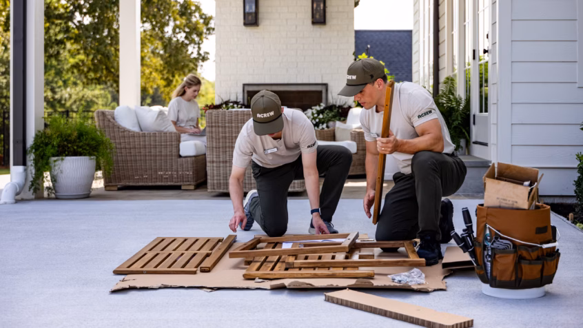 Two men assembling patio furniture, practicing home-service marketing.